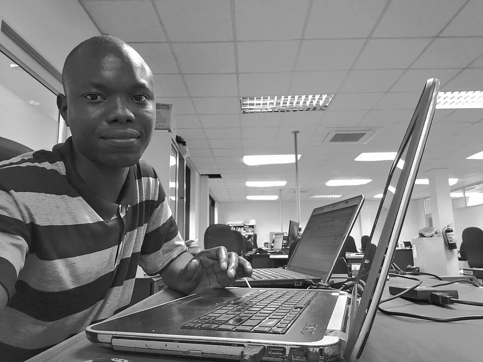 Software developer using computers at work — real photograph